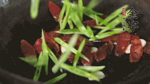 先后下香腸片、四季豆絲均勻翻炒，加適量清水燜煮一下。