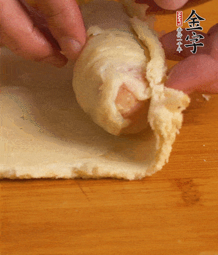 吐司卷起香腸，吐司尾端涂抹少許全蛋液，卷好的吐司表面蘸上蛋液，在裹上一層面包糠，送入預(yù)熱好的烤箱中。