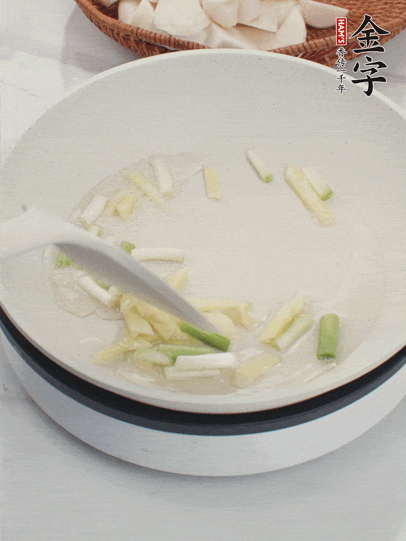 鍋中油五成熱，下蔥白、姜片爆香。