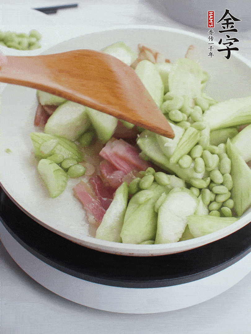 依次下絲瓜、青豆翻炒，炒至絲瓜打蔫縮小。