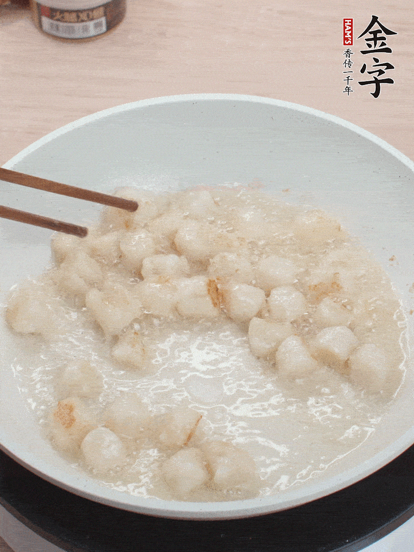 油溫4成熱，鮮貝蘸干淀粉下鍋煎，一面微黃后翻面。