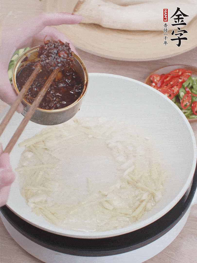 起鍋熱油，姜蒜、金字火腿干貝醬煸香。