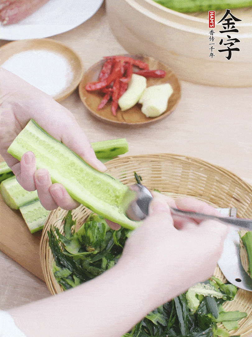 黃瓜削皮，對(duì)半切開，勺子挖去內(nèi)瓤，斜刀切片。青蒜斜刀切段。
