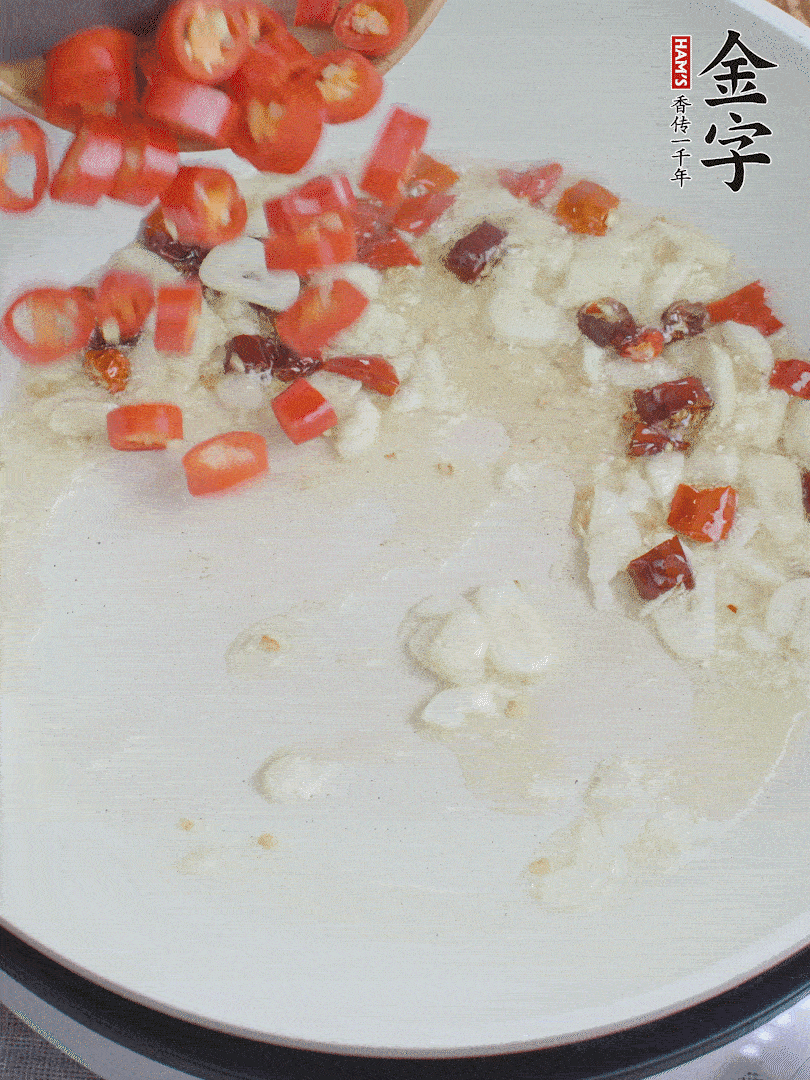 油6成熱，下蒜末、干紅辣椒煸炒，出香味后再放美人椒、香腸。