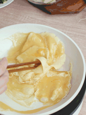 油6成熱時(shí)，下雞蛋液，邊緣凝固時(shí)翻拌成塊狀。