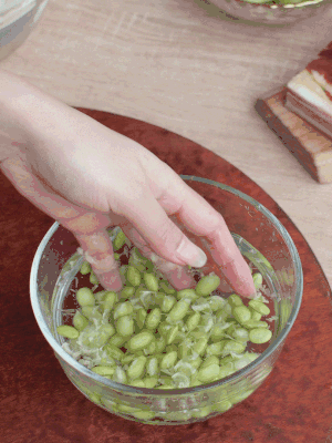 青豆剝殼，搓去外衣。