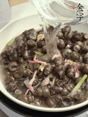 倒處理干凈的螺螄翻炒，加3勺料酒。加清水蓋過螺螄，中火蓋蓋煮5分鐘。