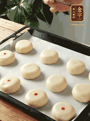 收口向下放在案板上，輕輕將月餅坯按扁，用筷子點(diǎn)紅點(diǎn)做裝飾