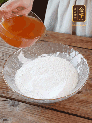 轉(zhuǎn)化糖漿、枧水、花生油攪拌均勻，加入面粉混合，醒發(fā)2小時。捏成23g一個的小球